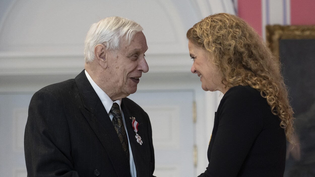 Walter Learning souriant pendant que Julie Payette le félicite avec une poignée de main.