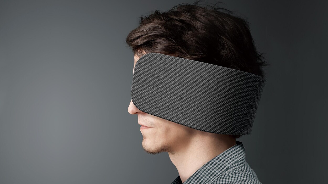Une photo montrant un homme qui porte les écouteurs Wear Space, qui ressemblent à de grosses œillères.