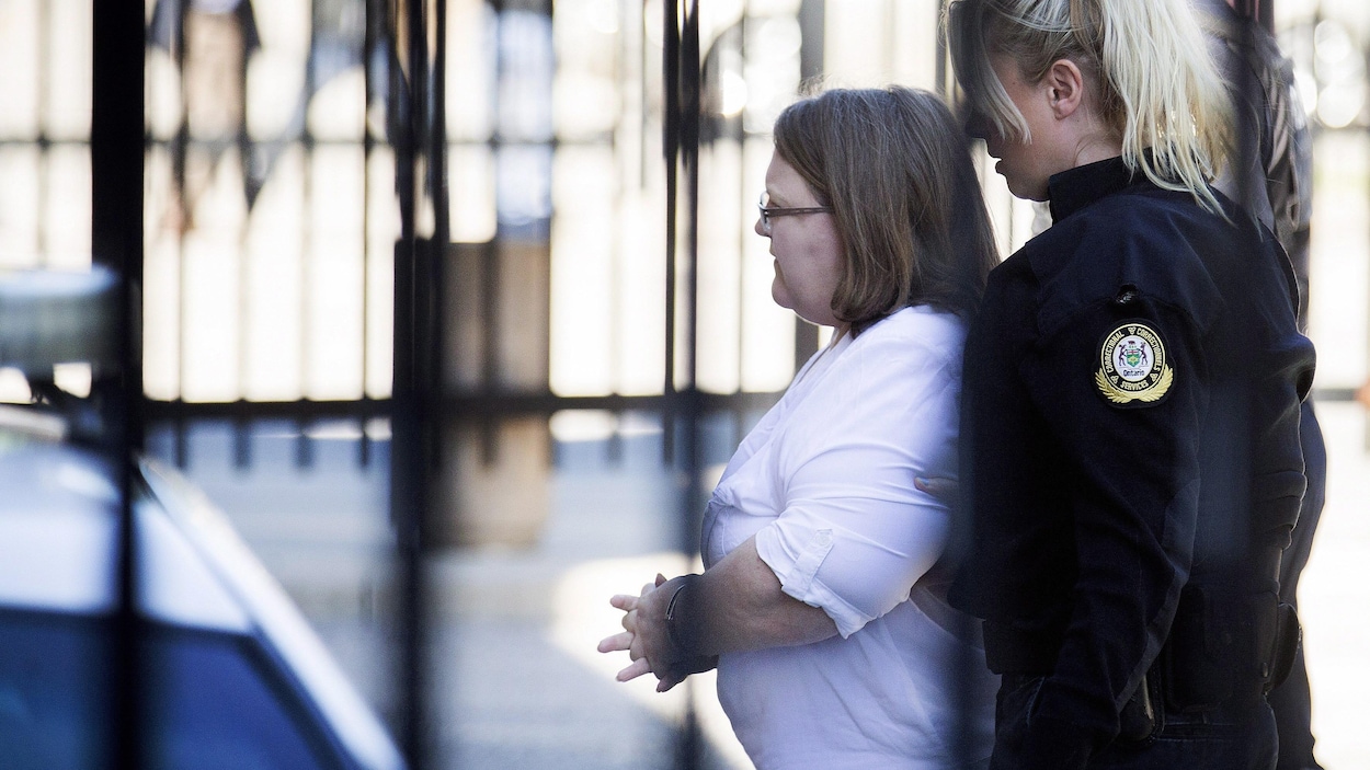 Photo de Wettlaufer qui est suivie par une policière alors qu'elle se dirige vers le tribunal.