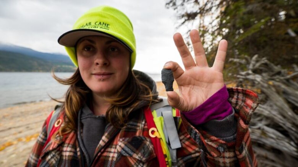 L'archéologue Whitney Spearing tient la tête de flèche.