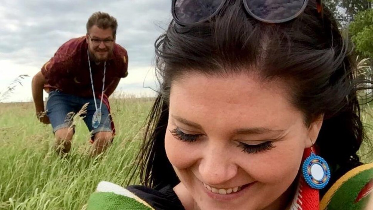 Une femme et un homme dans un champ de blé vert.