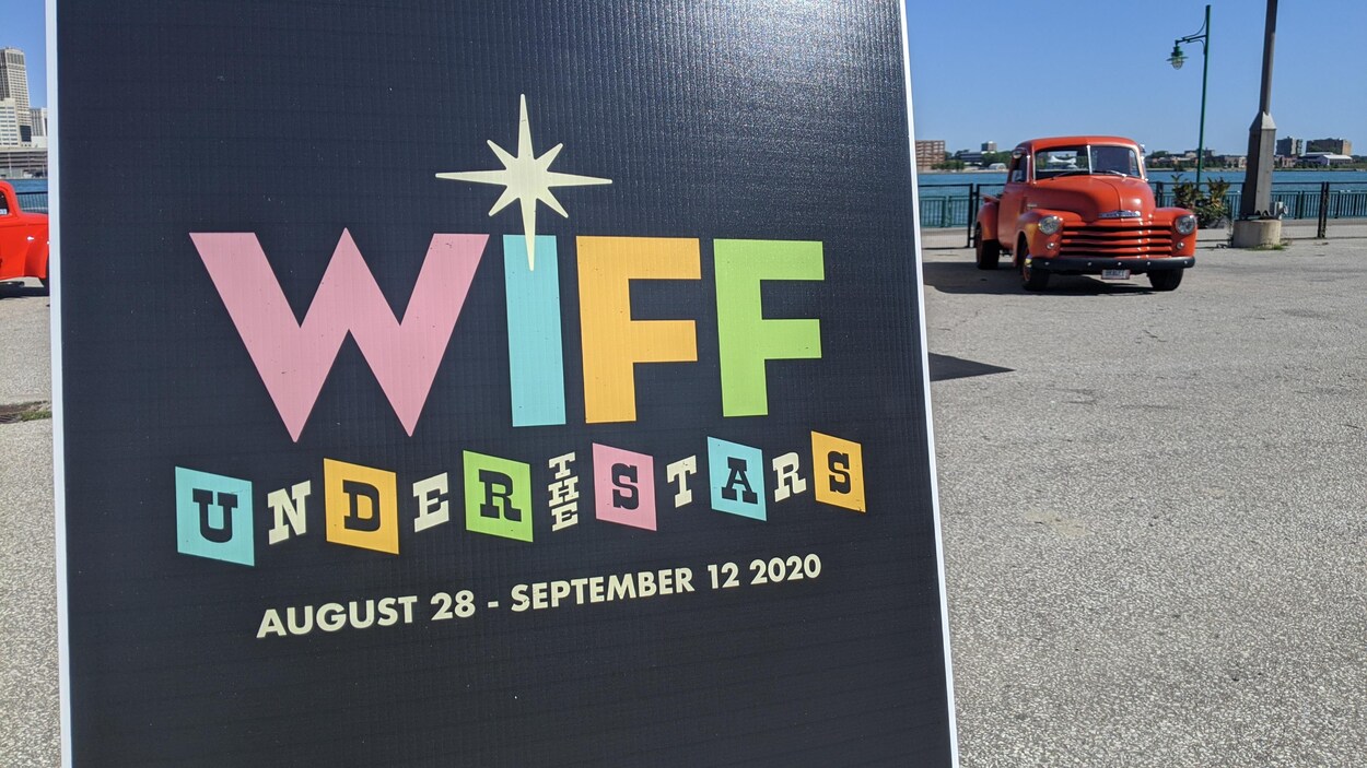 Une pancarte annonçant le nouveau festival avec une voiture en second plan.