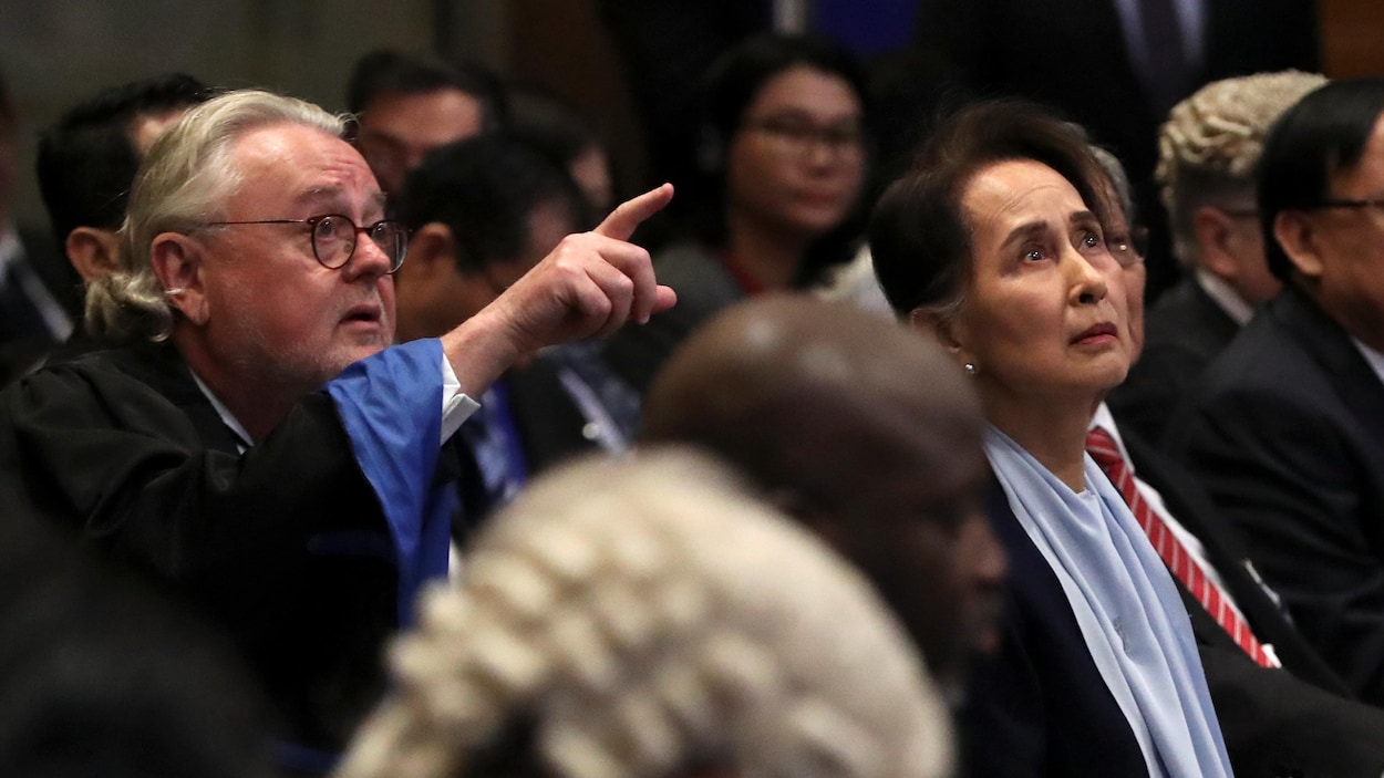 Me Schabas pointe du doigt vers quelque chose que regarde Mme Suu Kyi.
