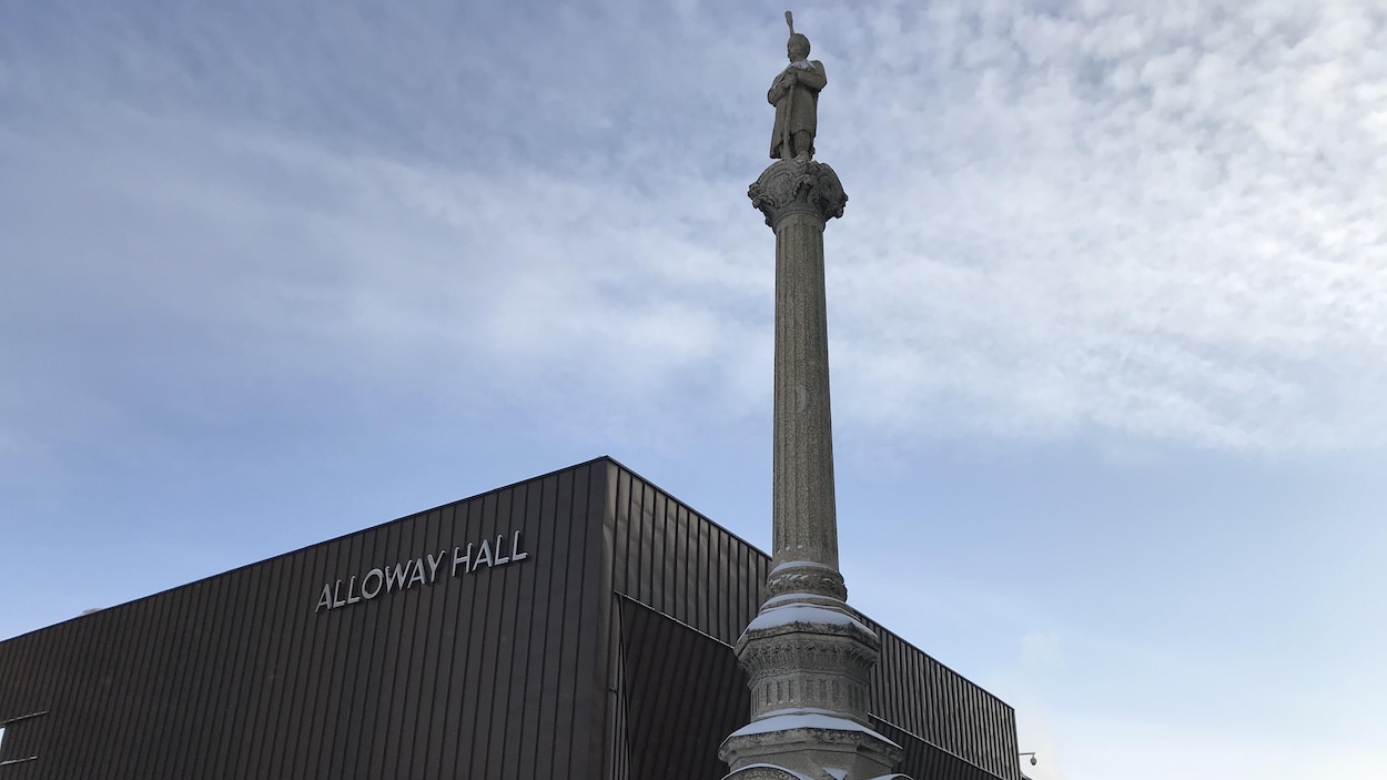 Une monument avec une colonne et une statue d'un soldat trônant sur cette colonne.