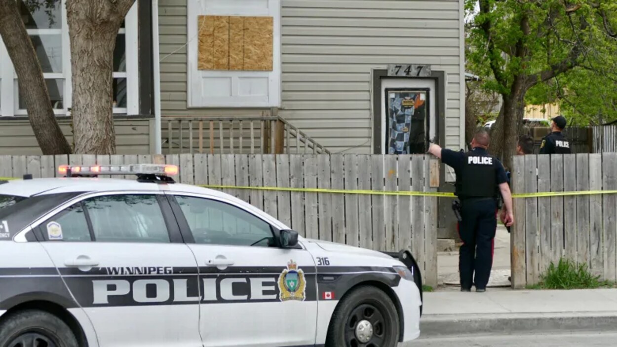 Des policiers devant une maison.