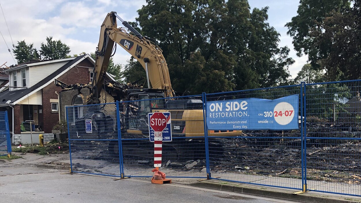 un chantier après la démolition d'une maison, on voit un appareil qui ramasse les débris qui jonchent le sol