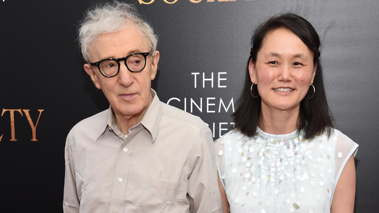 Woody Allen et Soon-Yi Previn se tiennent côte à côte. Le réalisateur regarde sur le côté, tandis que sa femme sourit aux objectifs. Woody Allen et Soon-Yi Previn se tiennent côte à côte. Le réalisateur regarde sur le côté, tandis que sa femme sourit aux objectifs.