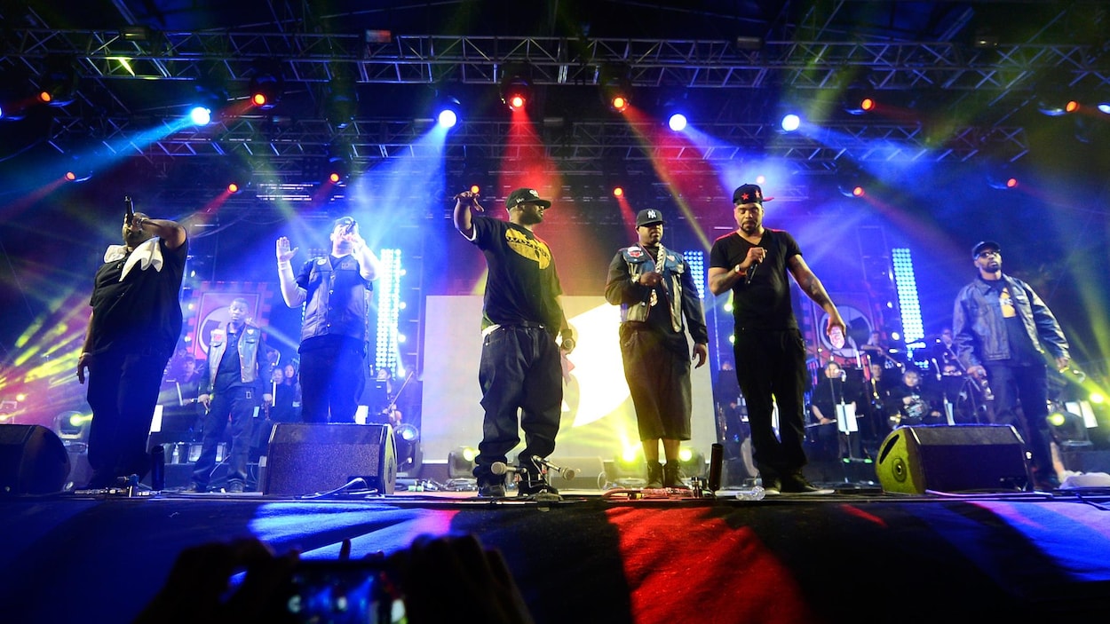 Les membres du groupe Wu-Tang Clan en train de donner une performance sur une scène de festival.