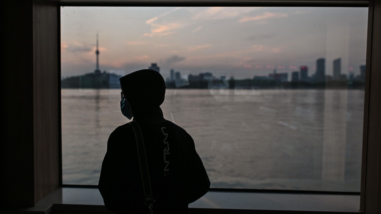 Un homme porte un masque dans un traversier sur la rivière Yangtze, à Wuhan, en Chine.
