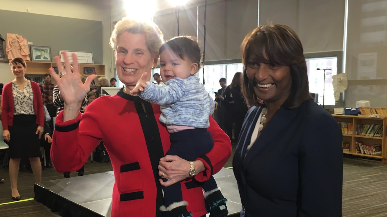 Photo de Kathleen Wynne qui tend la main à un bambin.