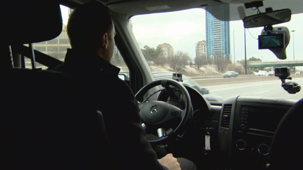 Un homme conduit sans toucher le volant dans un véhicule.