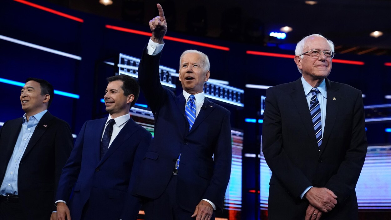 Andrew Yang, Pete Buttigieg, Joe Biden et Bernie Sanders sourient.