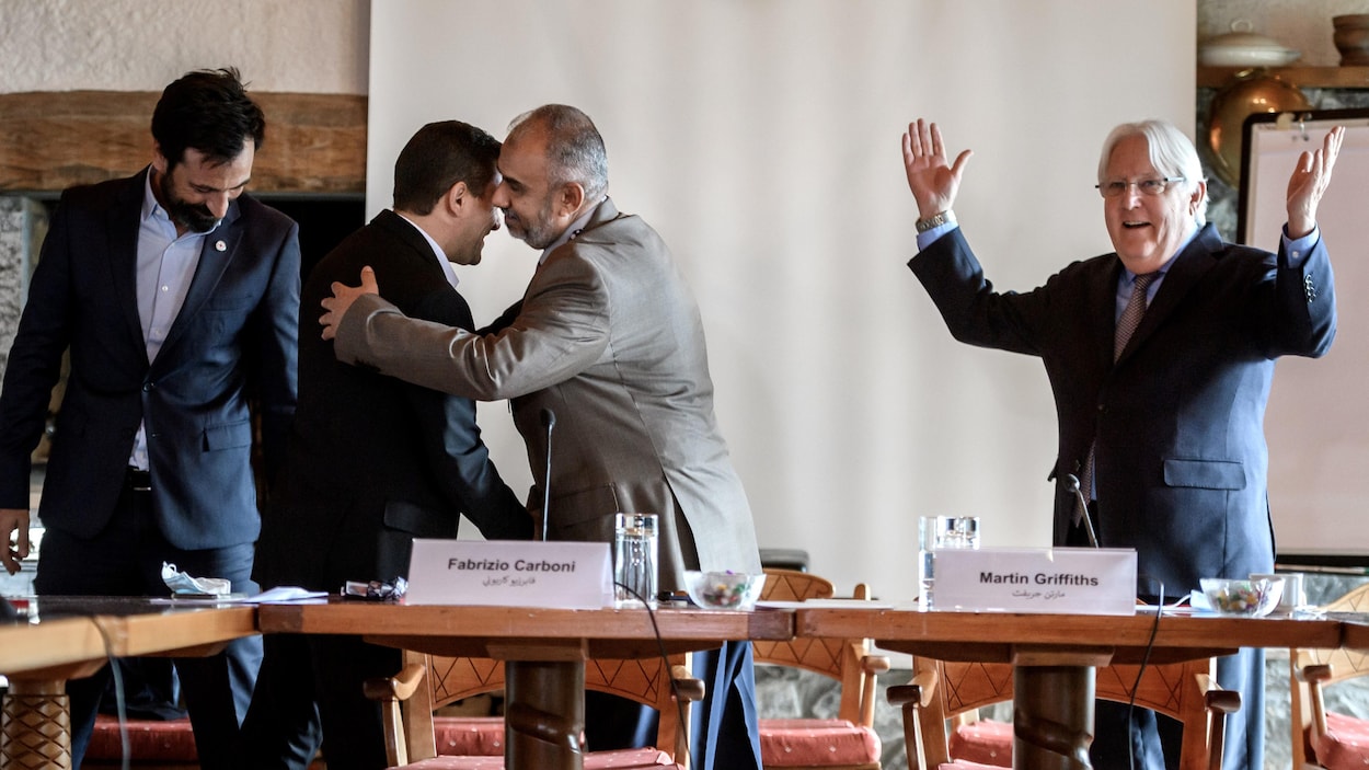 Les deux hommes se font une accolade.