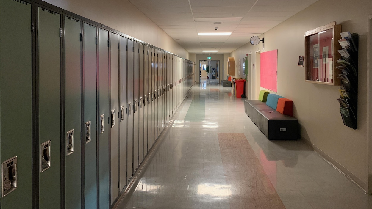 Un couloir vide avec des casiers dans une école.
