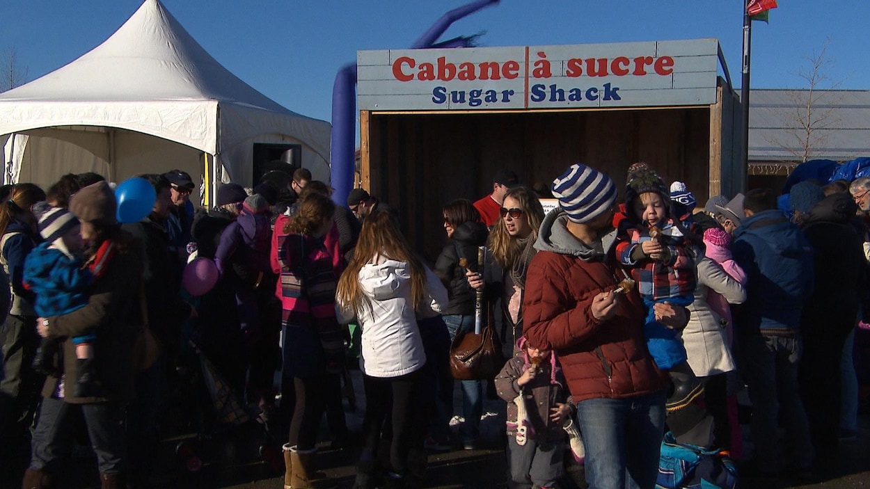 Une foule devant un kiosque qui affiche « cabane à sucre ».
