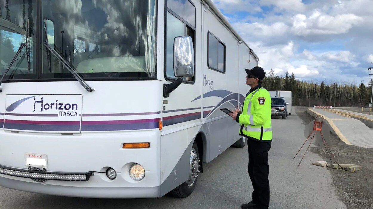 Un agent en uniforme échange à la fenêtre d'un véhicule récréatif.