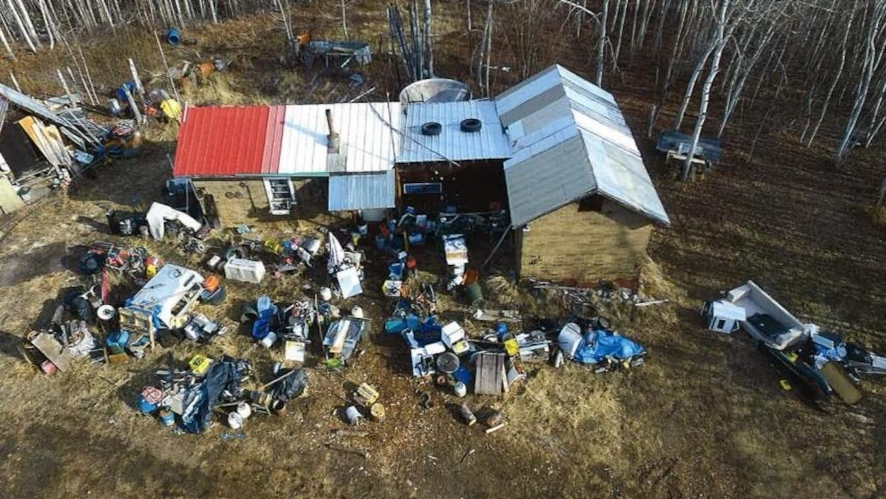 Propriété vue du haut des air montrant une cabane et beaucoup d'objets éparpillés.