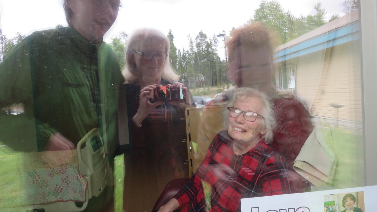 Égoportrait de la famille en visite avec une réflection dans la fenêtre.