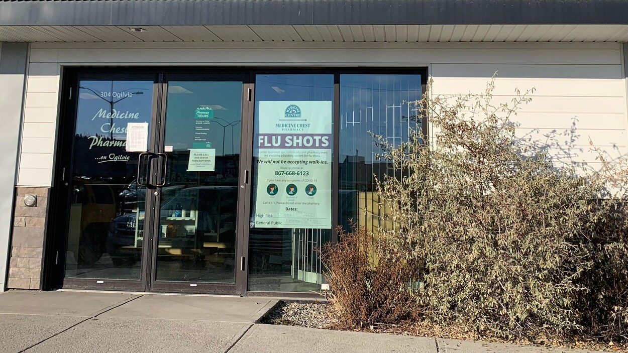 Façade d'une pharmacie qui affiche l'offre de vaccins.