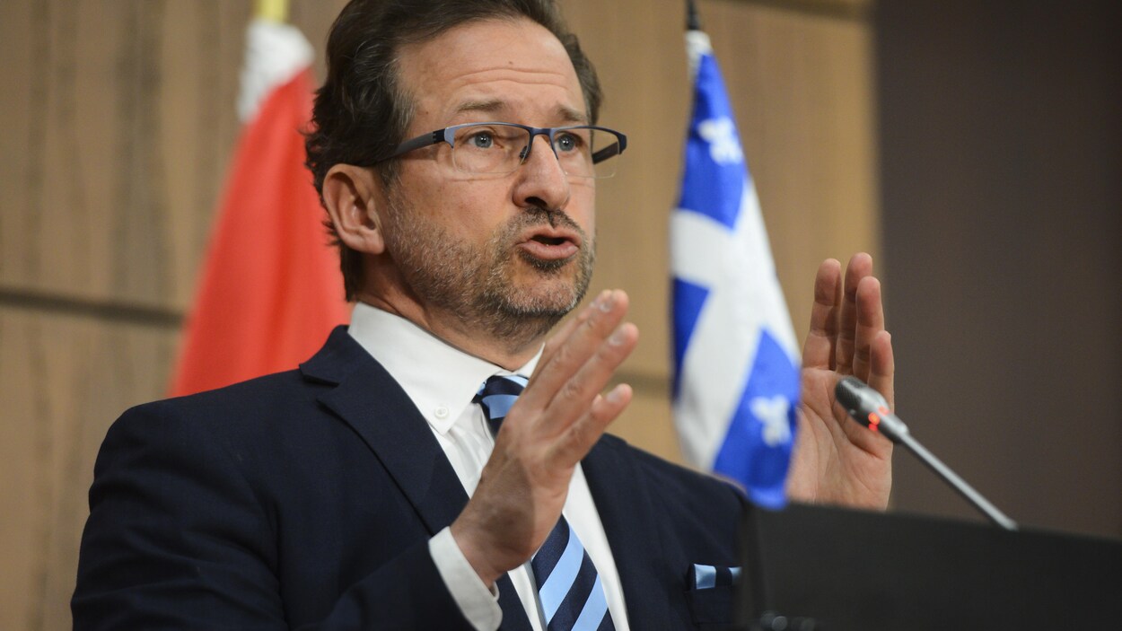 Yves-Francois Blanchet devant un lutrin sur lequel a été déposé un drapeau du Québec.
