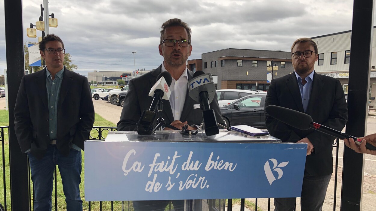 Yves-François Blanchet parle au micro accompagné de Mario Simard et d'Alexis Brunelle-Duceppe.