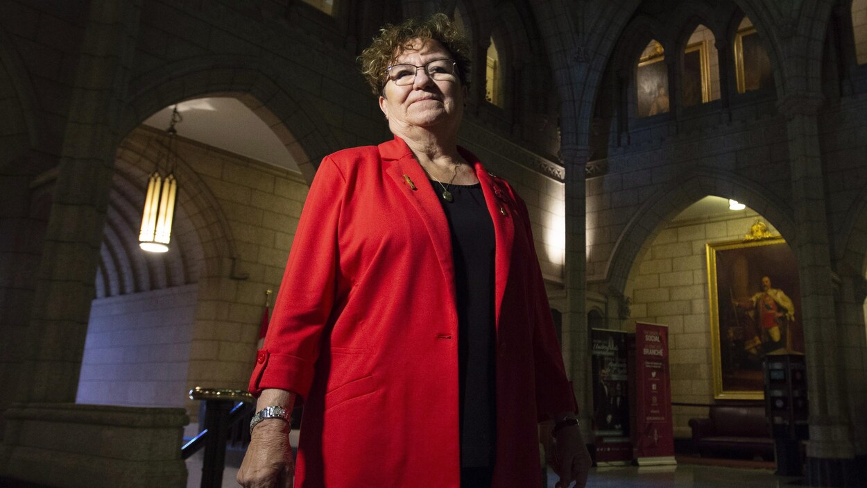 Yvonne Boyer debout, l'air confiant, dans le bâtiment du Parlement.