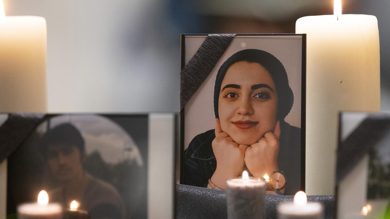 Une photo de Zeynab Asadi Lari est visible entre deux chandelles.