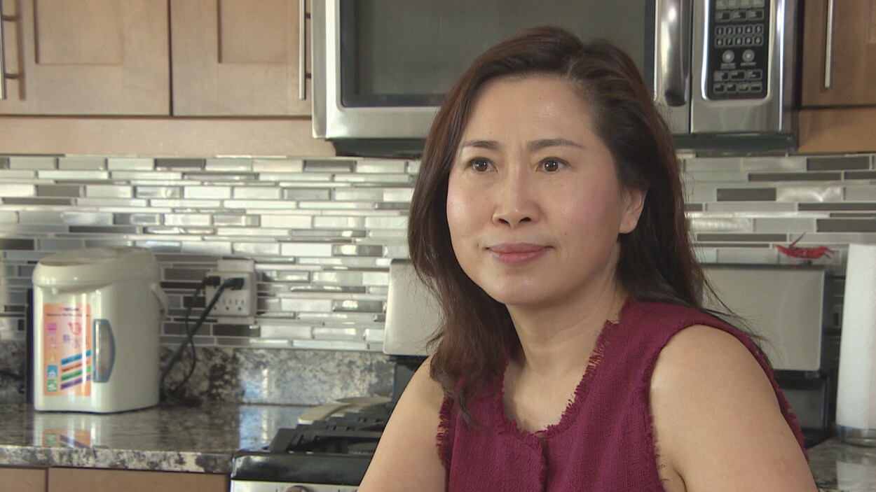 Plan moyen de Zhao Hui Fan assise dans sa cuisine.