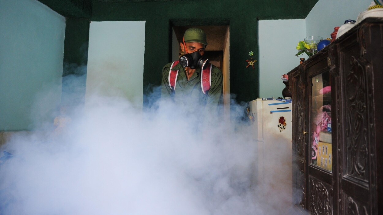 Un militaire cubain porte un masque lors d'une opération de fumigation.