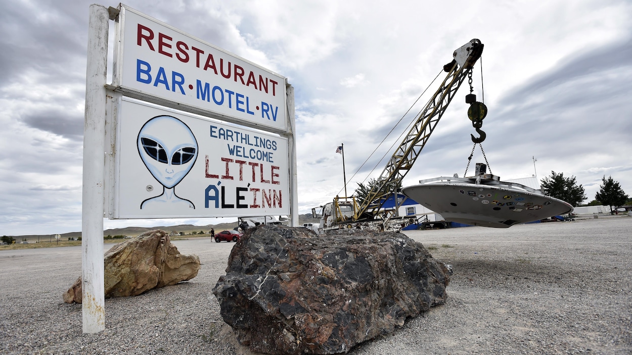 A photo of the sign of a restaurant on which is drawn an extraterrestrial.