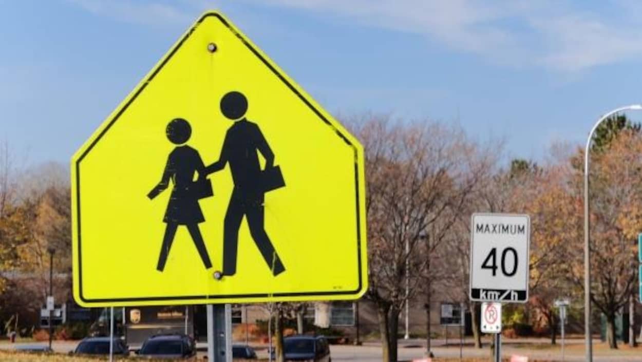 Des affiches annonçant une zone scolaire et une limite de vitesse de 40 km/h Des affiches annonçant une zone scolaire et une limite de vitesse de 40 km/h