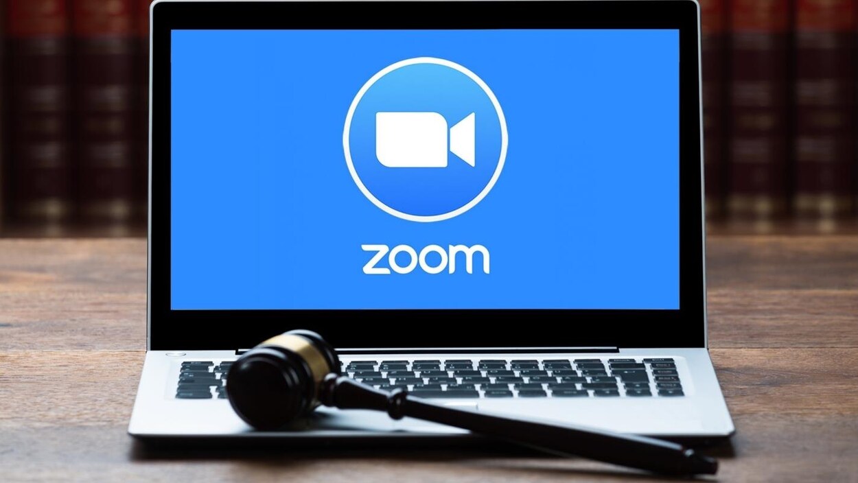 Un marteau de juge placé devant un ordinateur qui affiche le logo de Zoom.