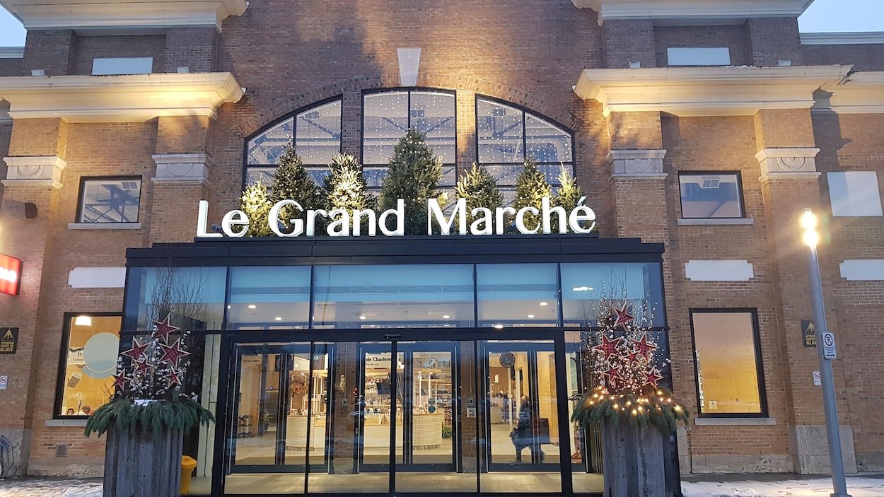 Entrée vitrée moderne sur une façade en briques avec l'inscription Le Grande Marché.