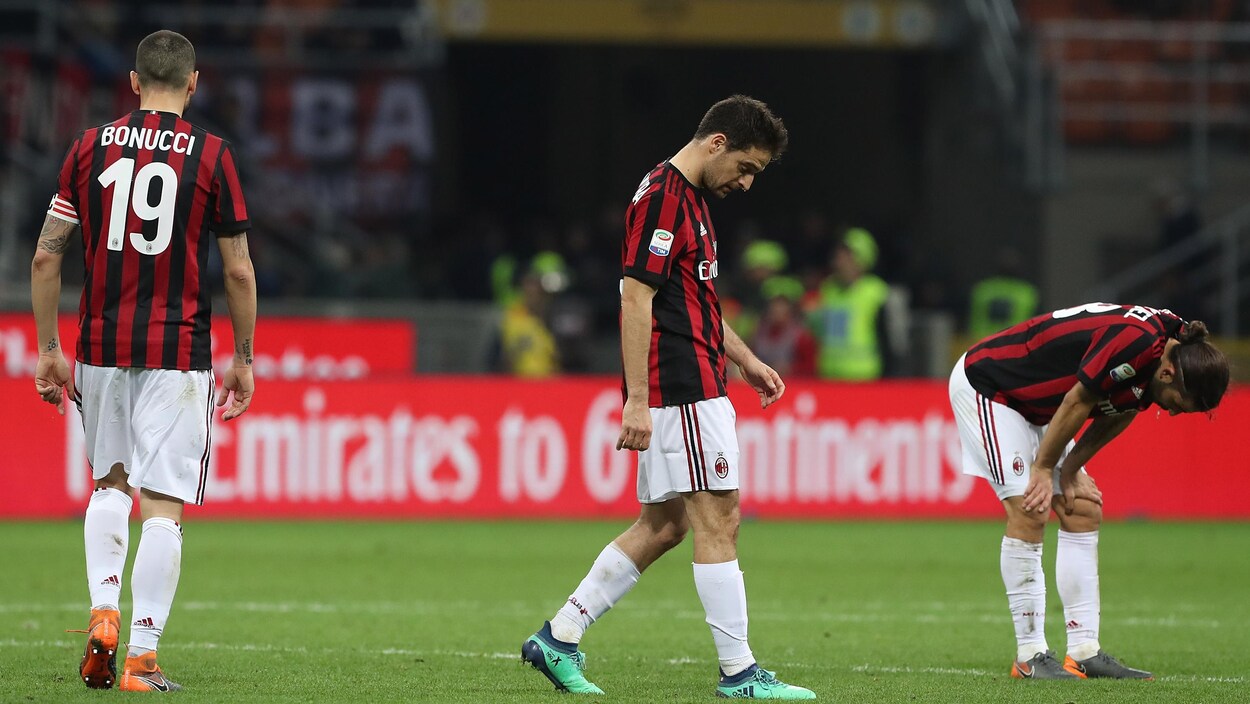 Des joueurs de l'AC Milan sur le terrain, la mine basse, après une défaite