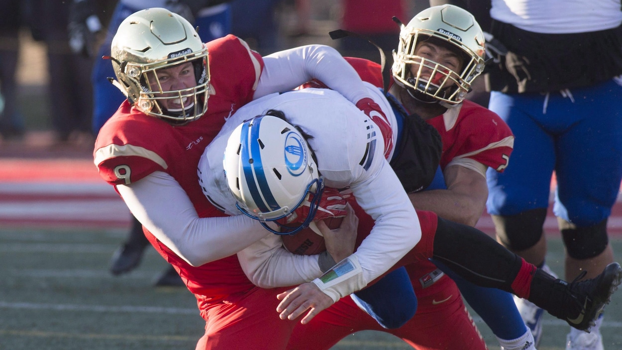 Deux joueurs du Rouge et Or parviennent à stopper un porte-couleurs des Carabins.