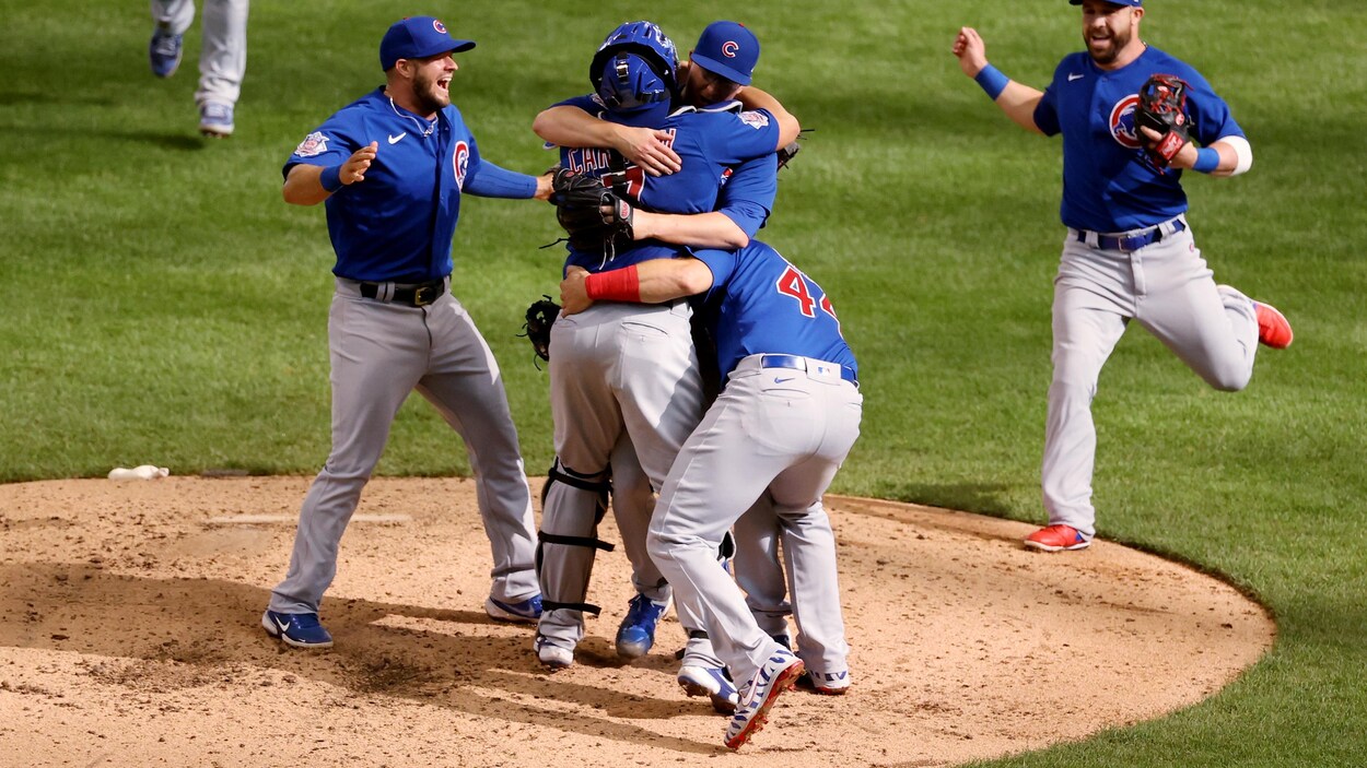 Sur un monticule, des joueurs de baseball en enlacent un autre.
