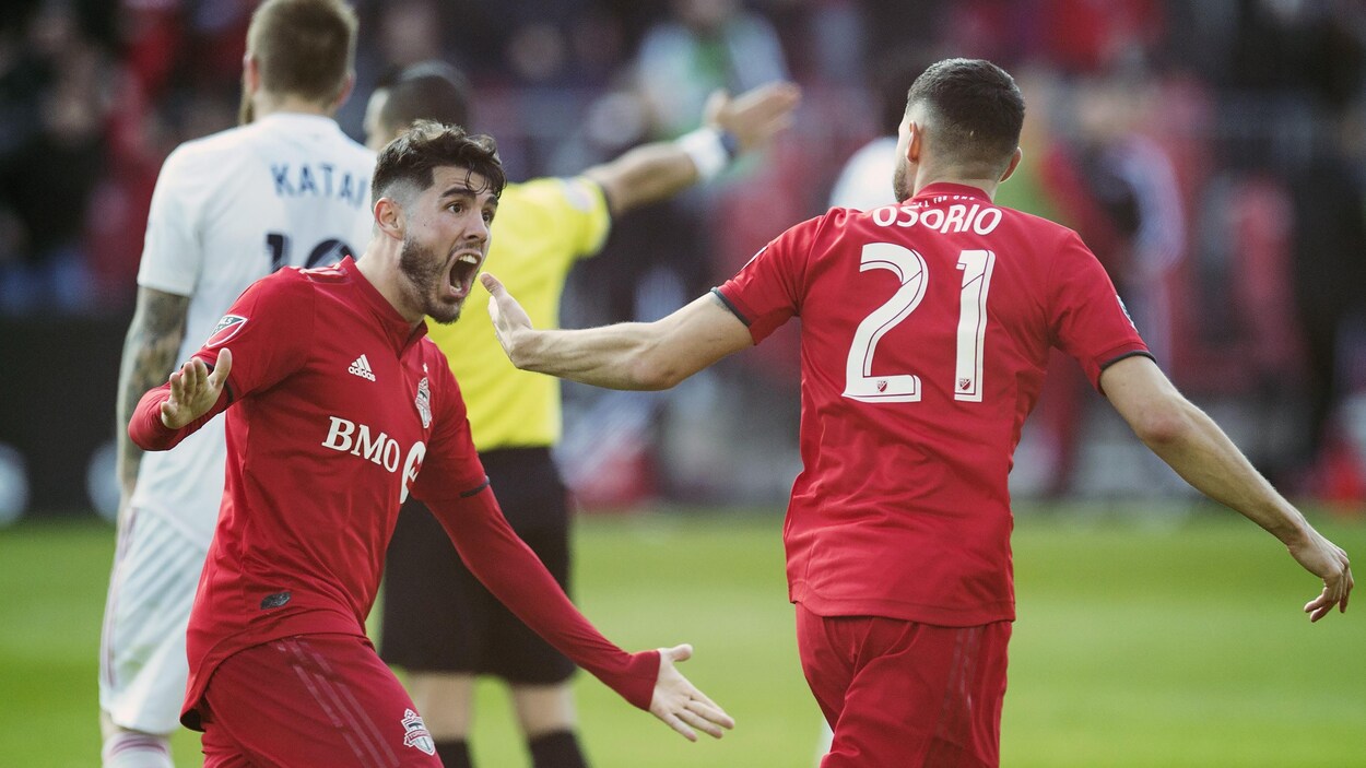 Deux joueurs de soccer célèbrent un but ensemble.