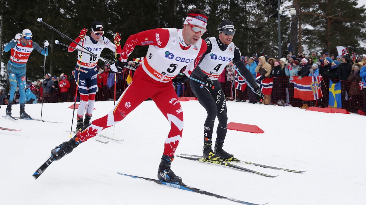 Alex Harvey devance Dario Cologna pendant le 50 km départ groupé de la Coupe du monde de Holmenkollen, en Norvège. Alex Harvey devance Dario Cologna pendant le 50 km départ groupé de la Coupe du monde de Holmenkollen, en Norvège.