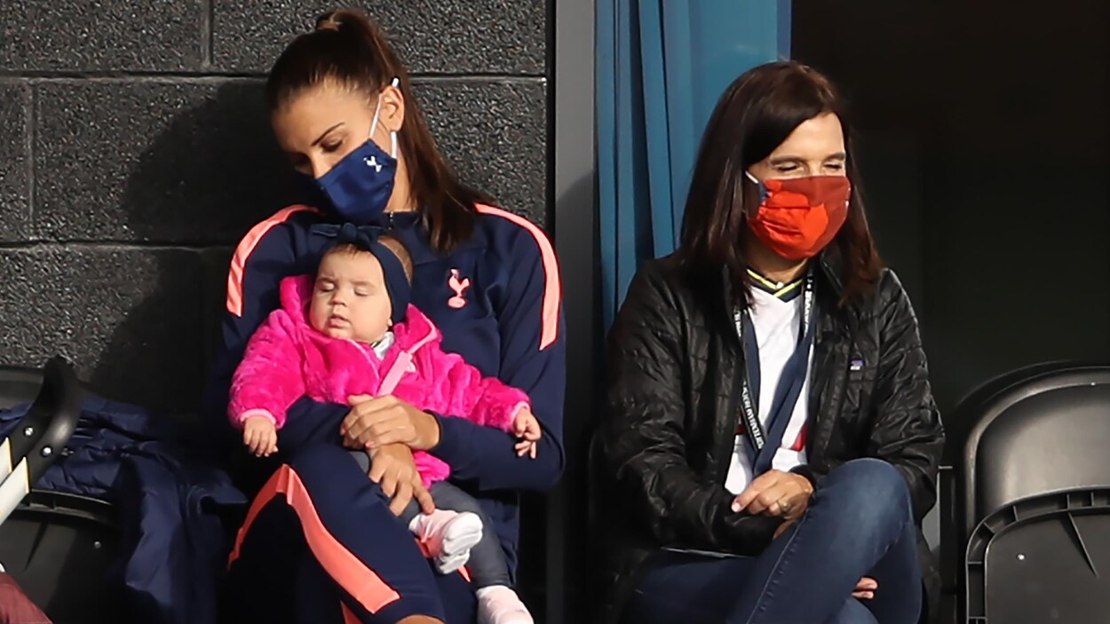 Une femme tient son jeune enfant dans ses bras.