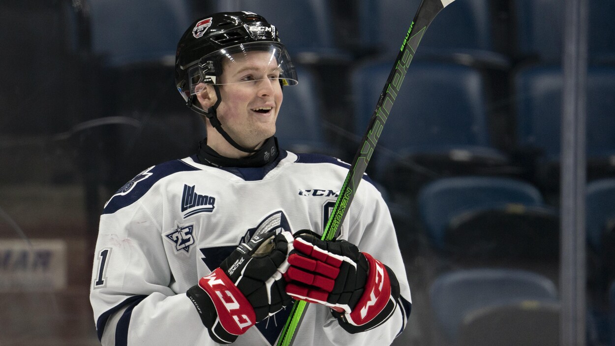 Alexis Lafrenière tient un baton de hockey dans ses mains.