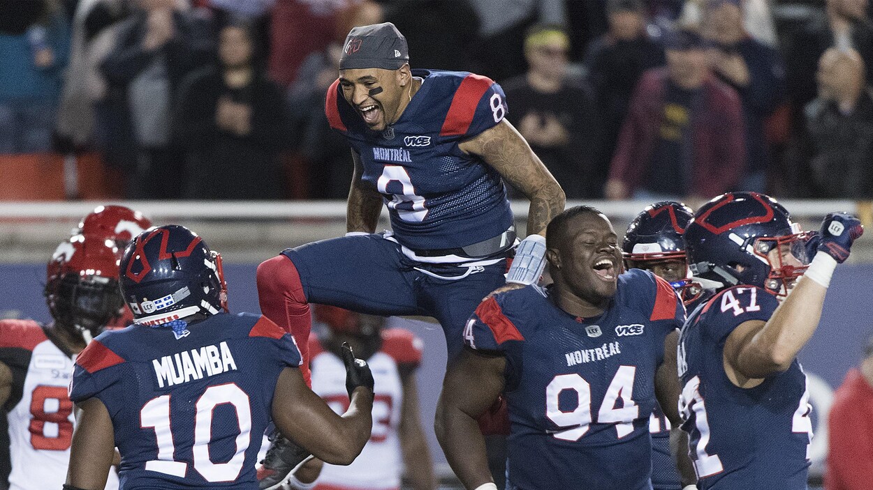 Le quart Vernon Adams saute dans les airs devant le secondeur Henoc Muamba après une victoire de 21-17 de Montréal contre Calgary.