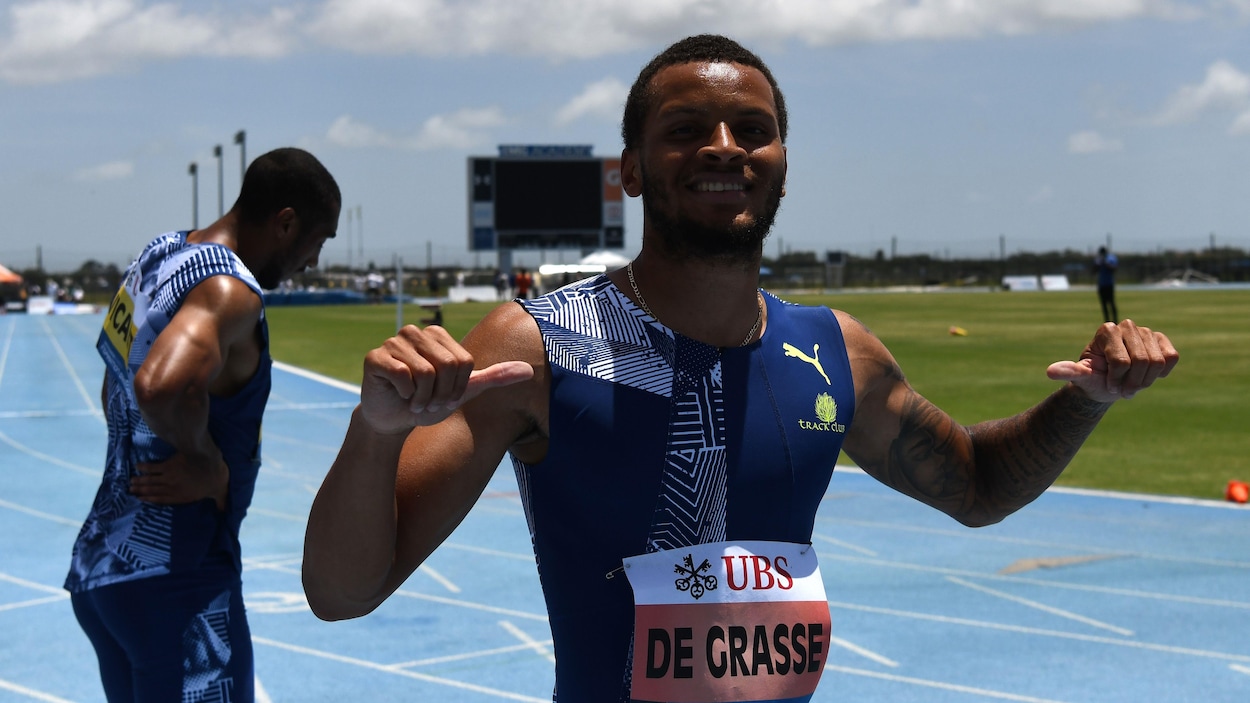 Andre De Grasse pointe ses pouces vers lui-même.