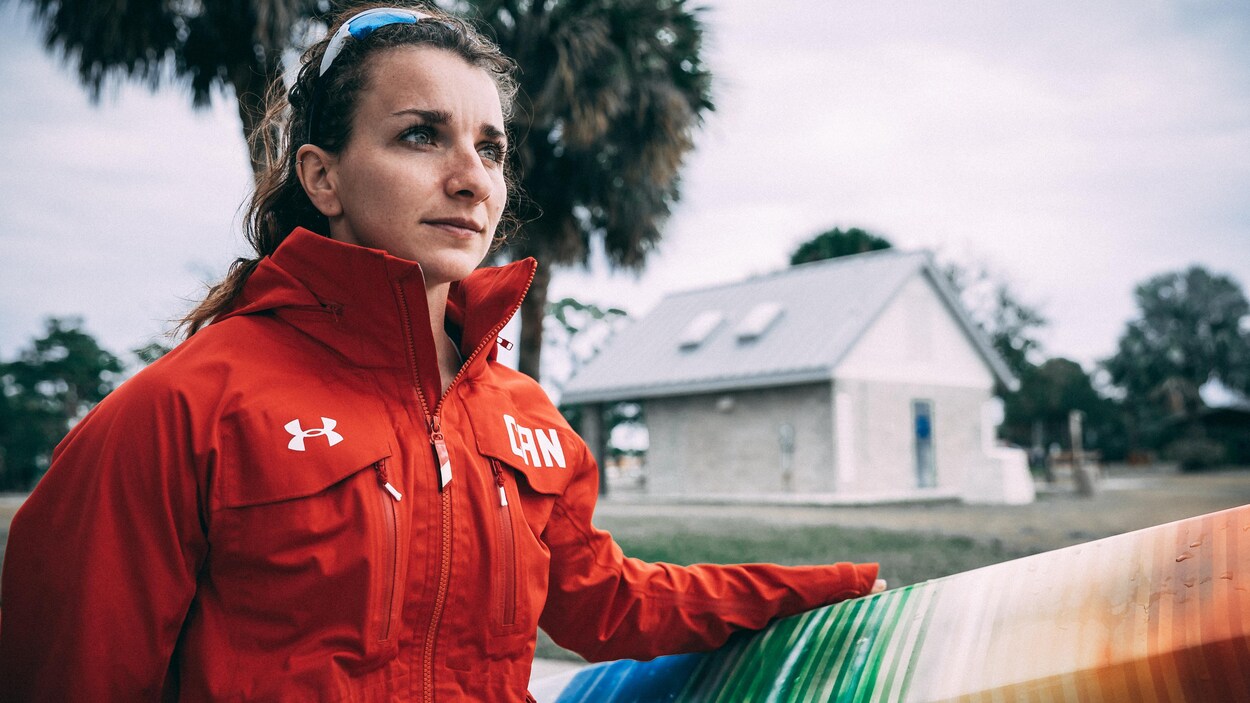 Andréanne Langlois regarde au loin, une main sur son kayak. Andréanne Langlois regarde au loin, une main sur son kayak.