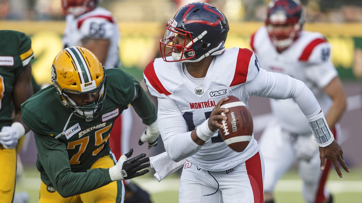 Le quart-arrière Antonio Pipkin, ballon en main, est pourchassé par Nick Usher, des Eskimos d'Edmonton.