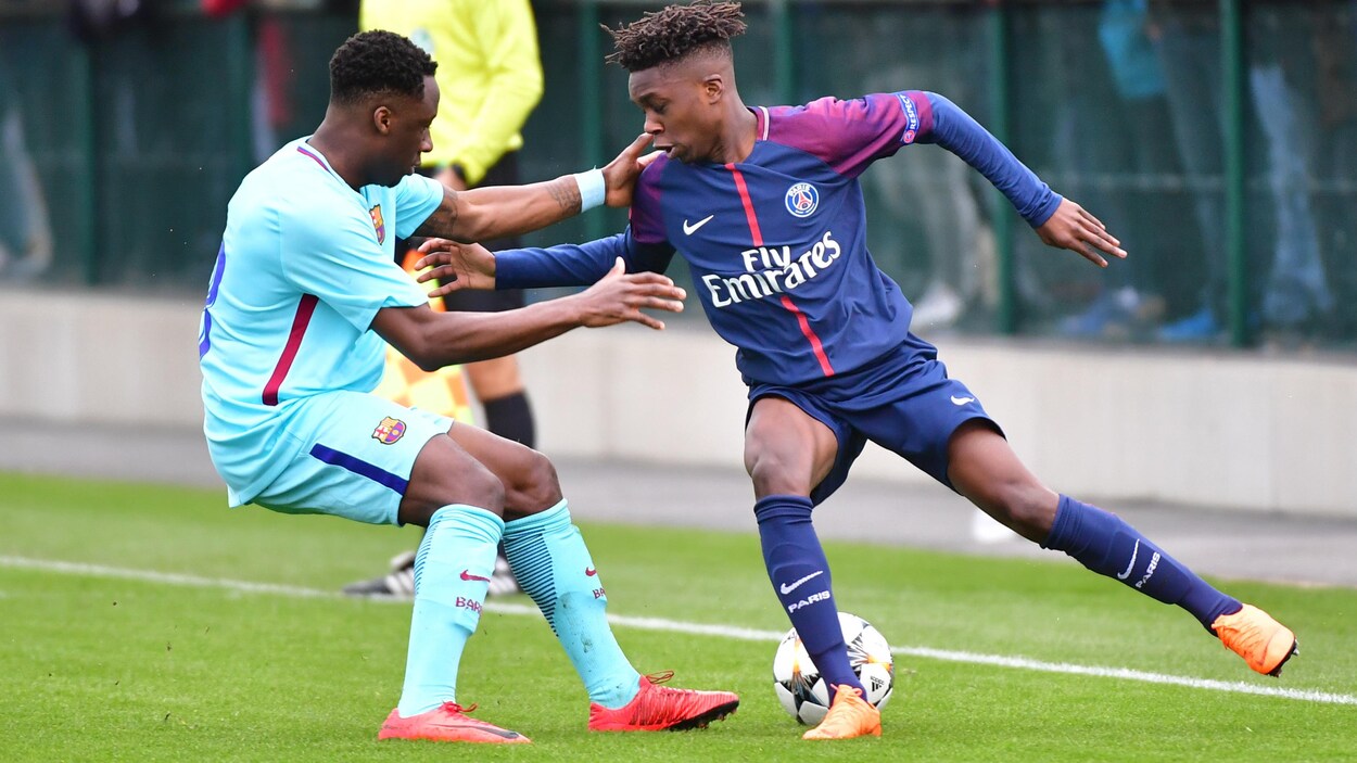 Ballou, du FC Barcelone B, bataille pour le ballon avec un adversaire du Paris Saint-Germain, en février 2018. Ballou, du FC Barcelone B, bataille pour le ballon avec un adversaire du Paris Saint-Germain, en février 2018.