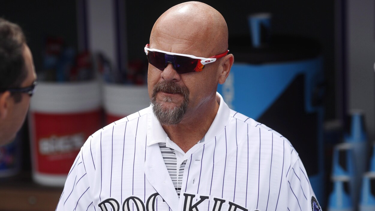 Un homme avec son vieil uniforme des Rockies porte des lunettes de soleil.