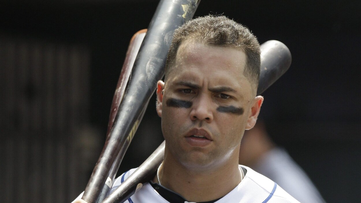 Il tient des bâtons de baseball dans ses mains.