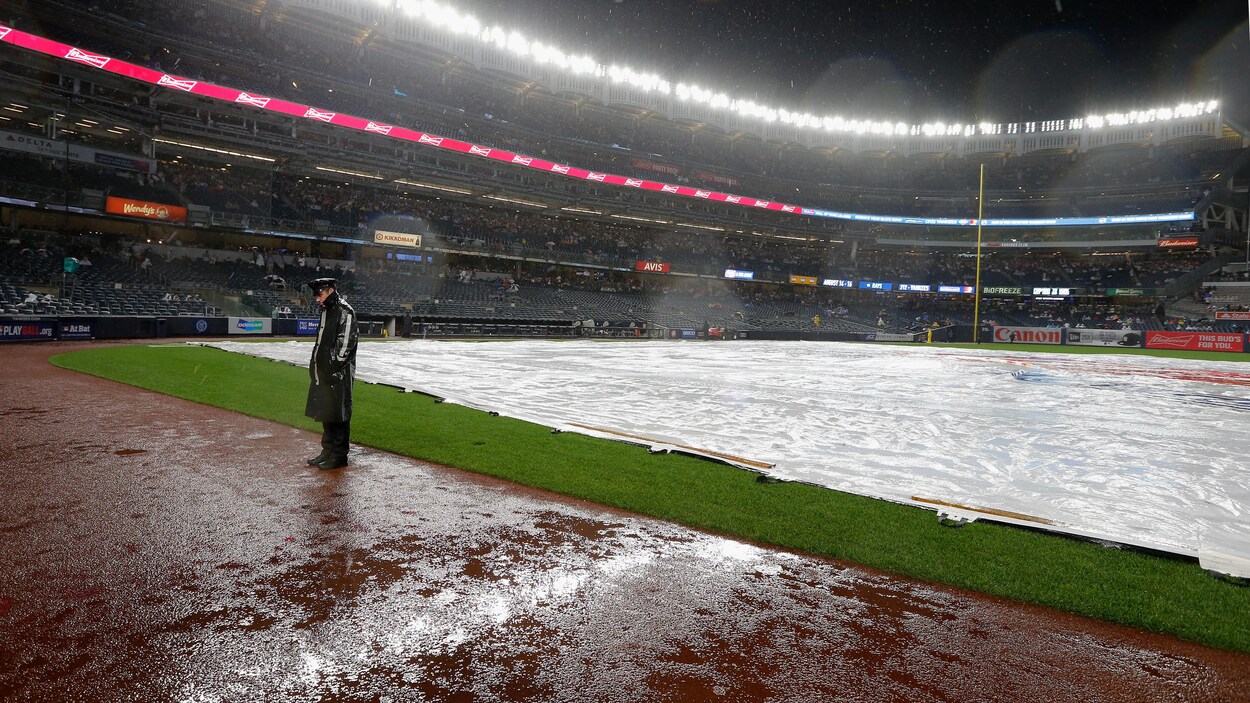 Un policier surveille le terrain du Yankee Stadium pendant une averse en 2018.