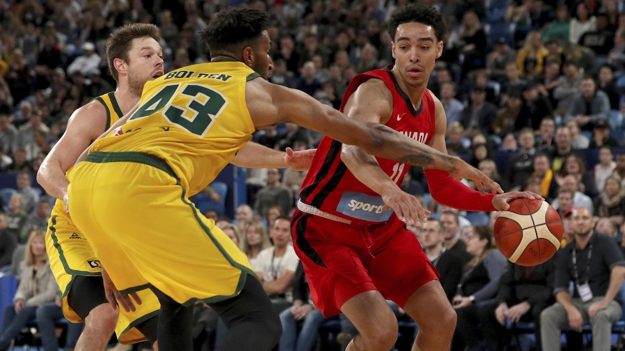 Le Canadien Andrew Nembhard contrôle le ballon, surveillé par l'Australien Jonah Anthony Bolden.