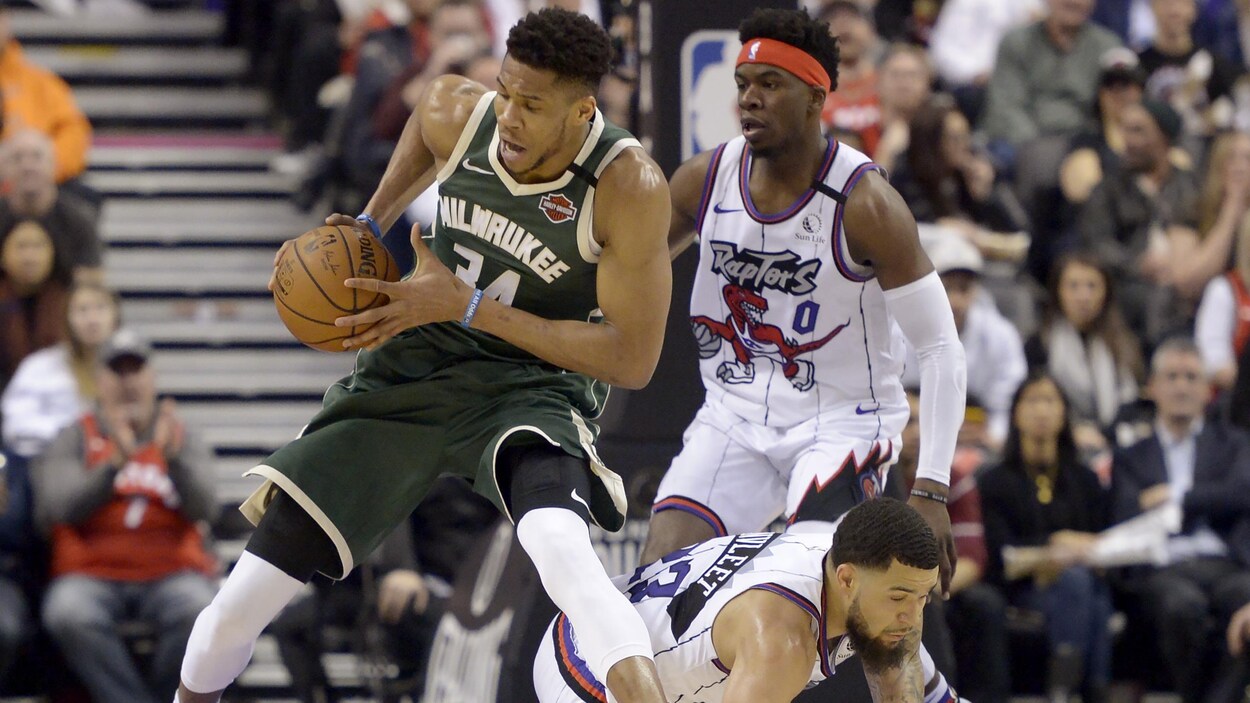 Antetokounmpo fait dos à Davis avec le ballon.